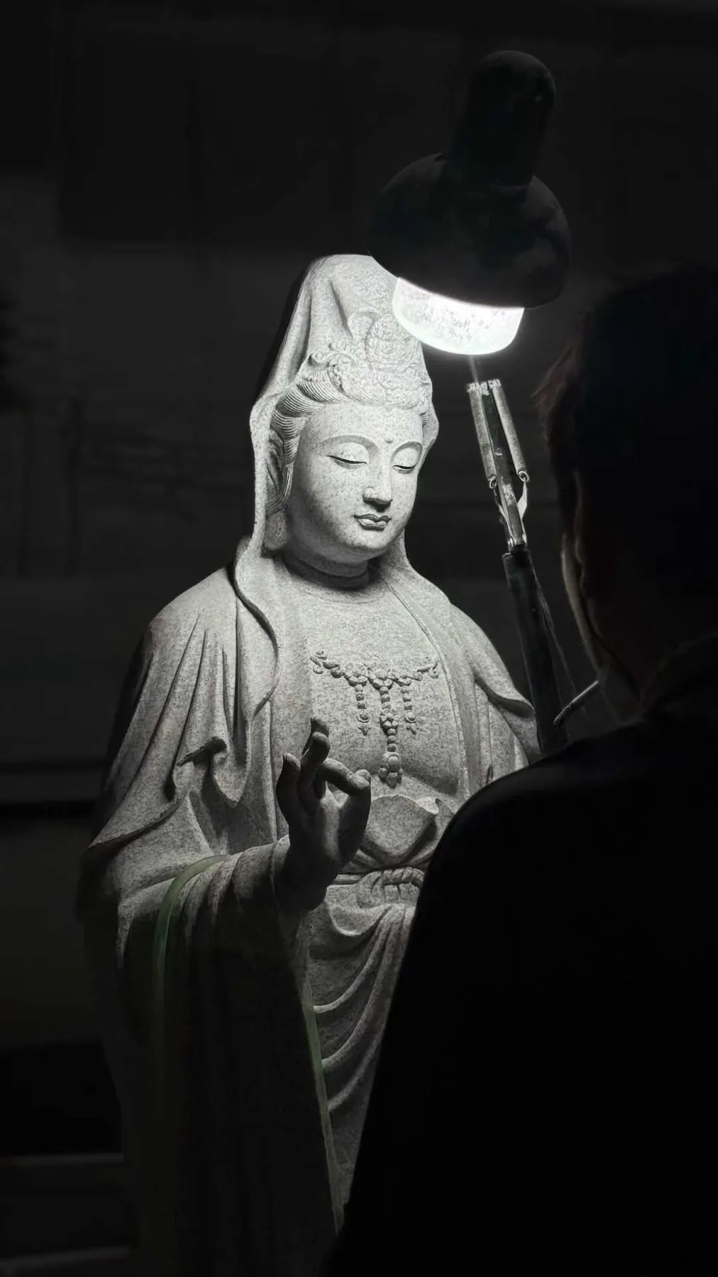 White marble Guanyin figure lit from the side in the Huian workshop