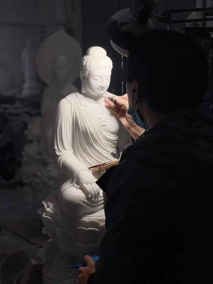 Carved stone Buddha figure on a lotus base in the workshop yard
